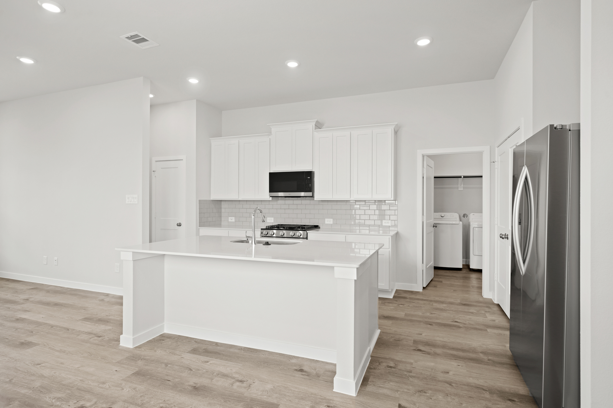 A kitchen with white cabinets.