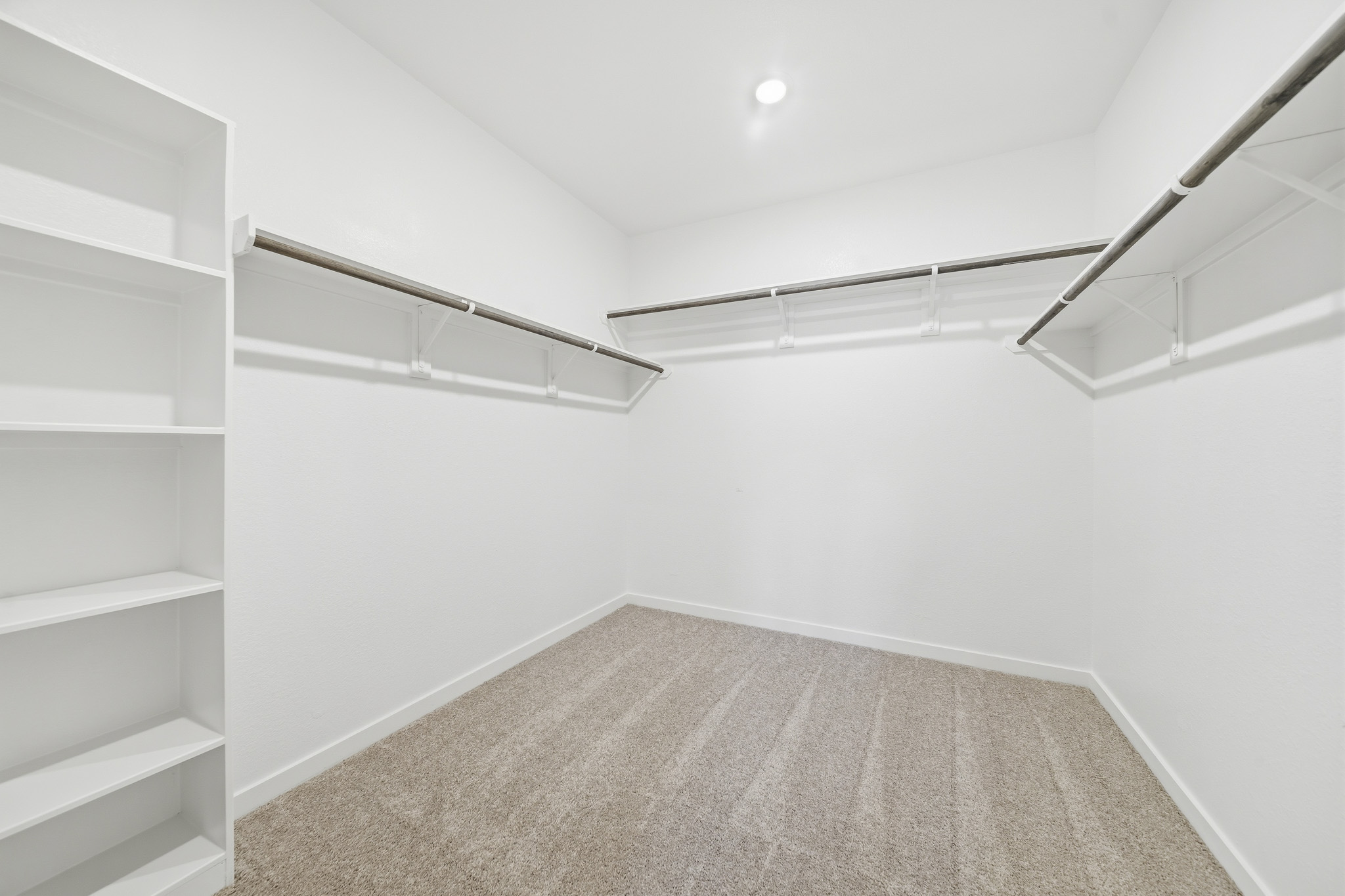 A white room with a carpet and a white wall.