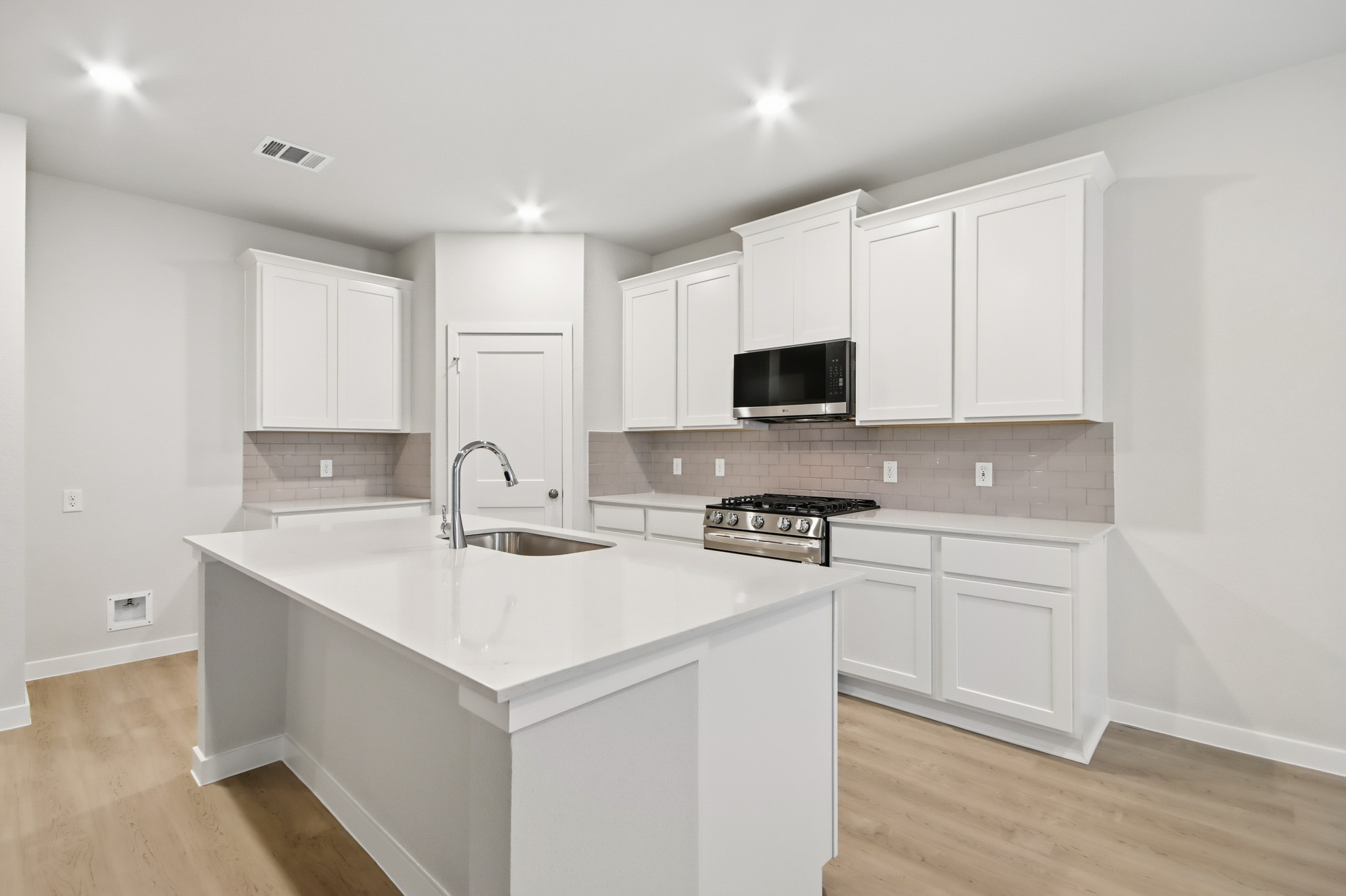 A kitchen with white cabinets.