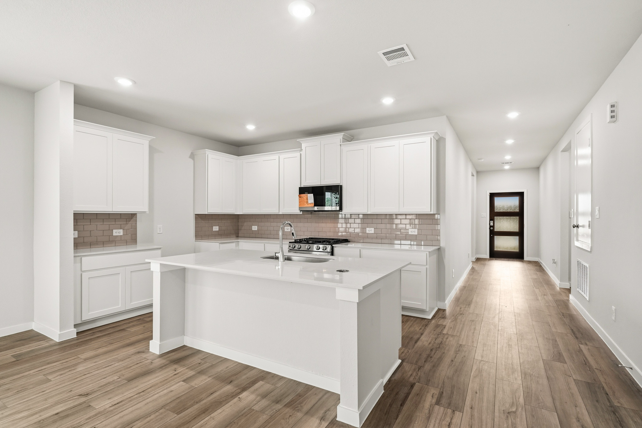 A kitchen with white cabinets.