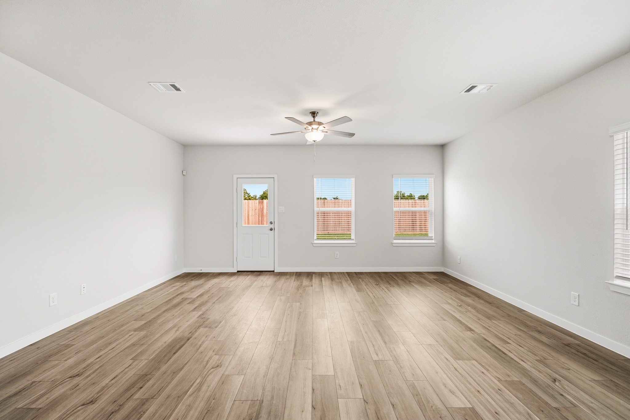A room with a wood floor and a ceiling fan.