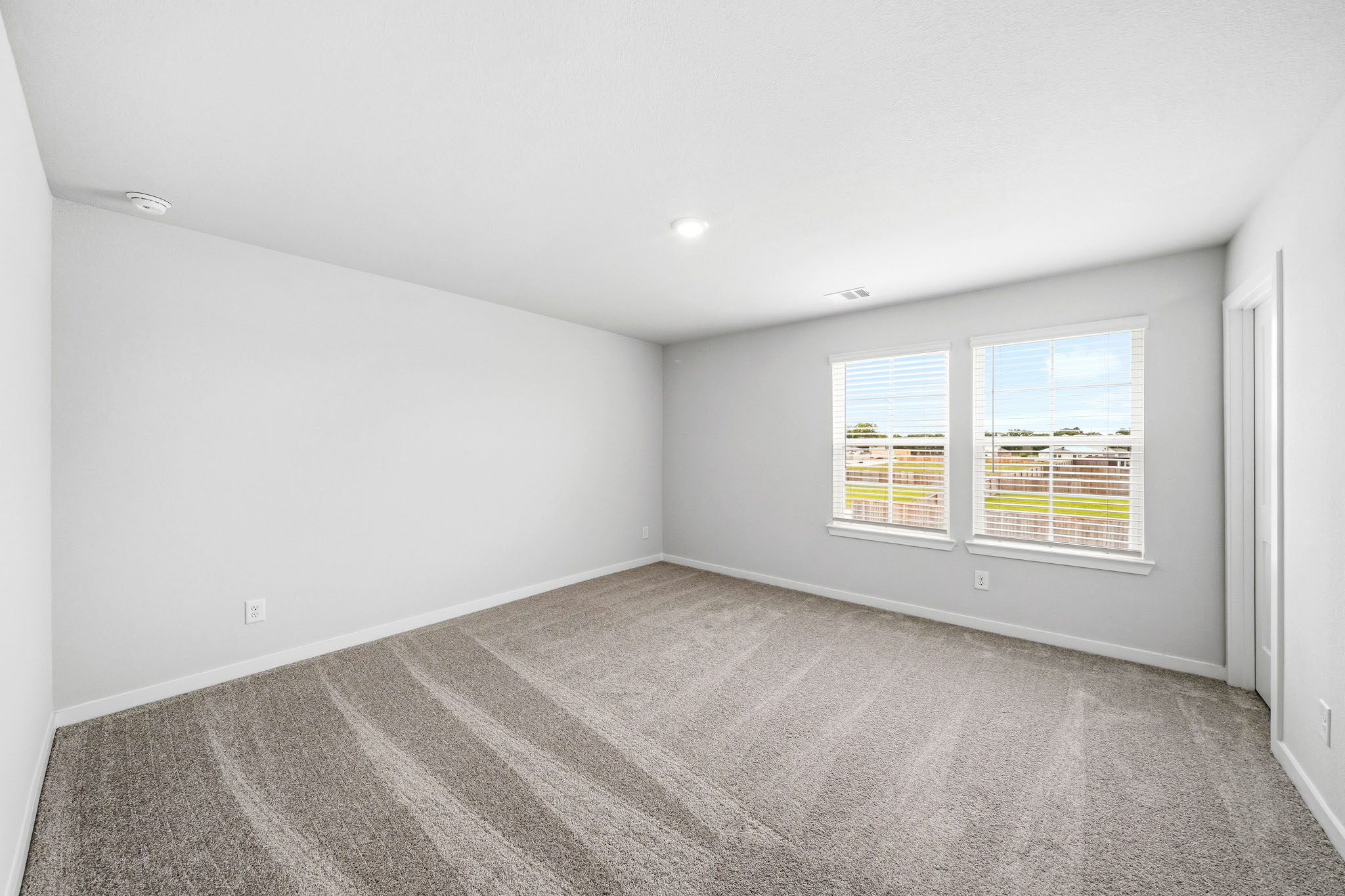 A room with a carpet and windows.