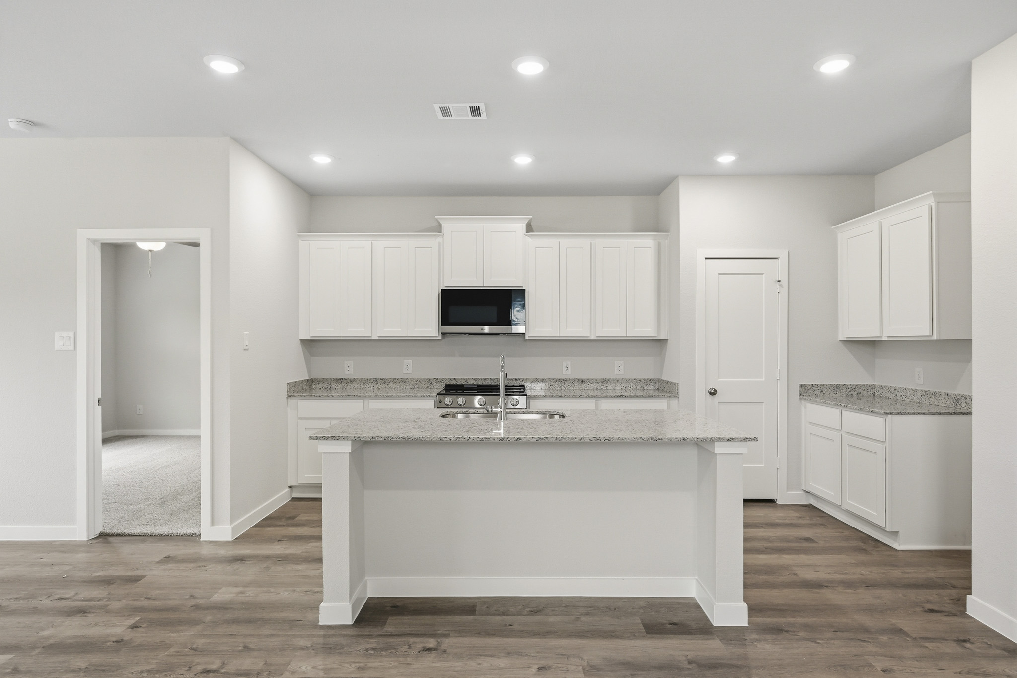 A kitchen with white cabinets.
