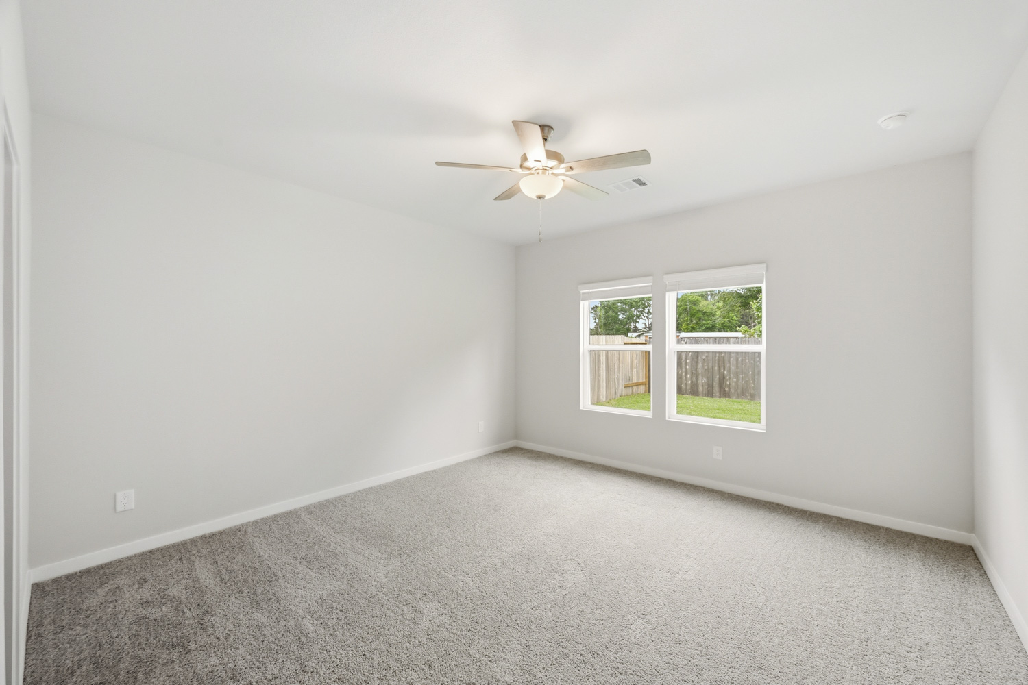 A room with a ceiling fan and a window.
