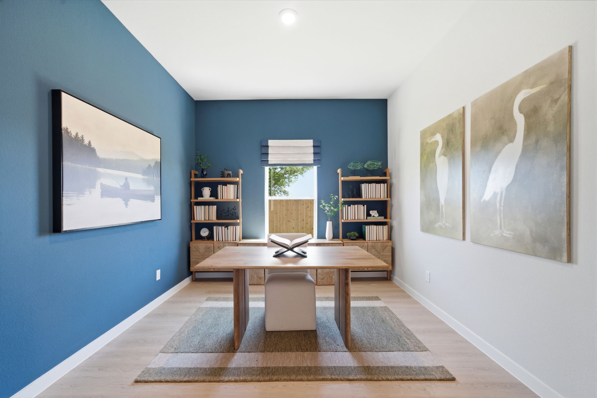 A room with a table and a book shelf.