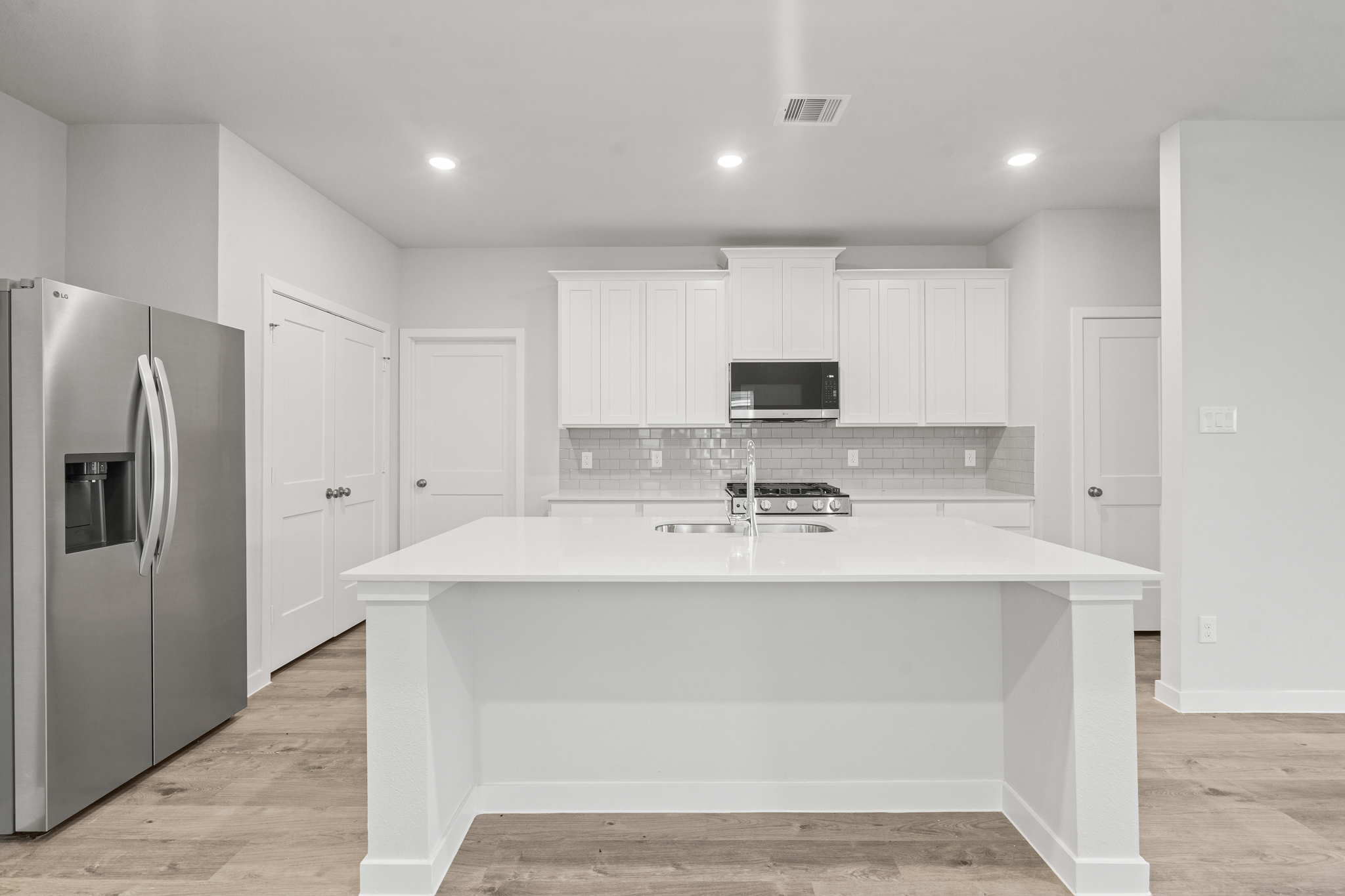 A kitchen with white cabinets.
