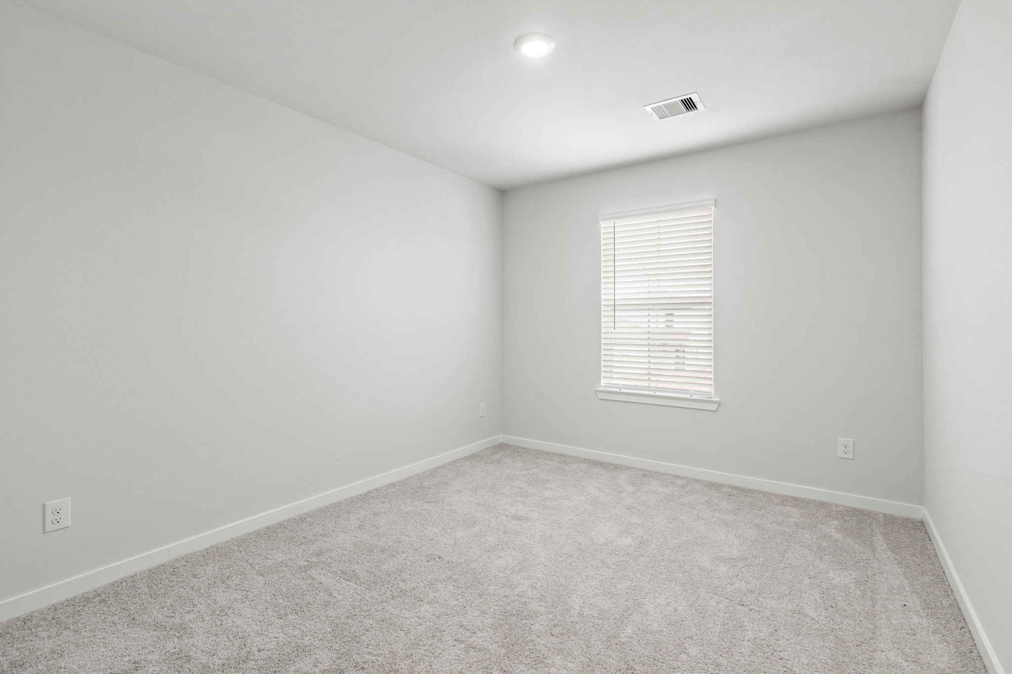 A room with a window and a carpet.