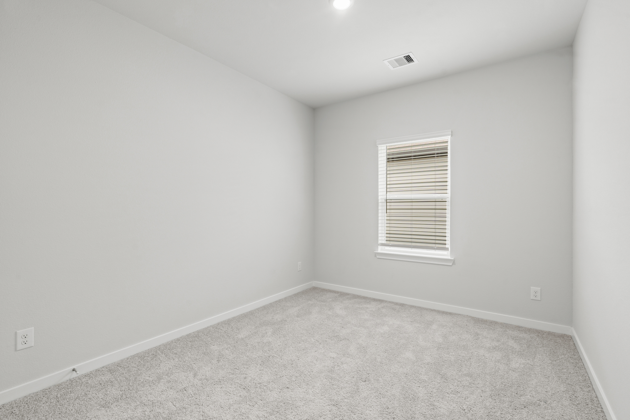 A room with a window and a carpet.