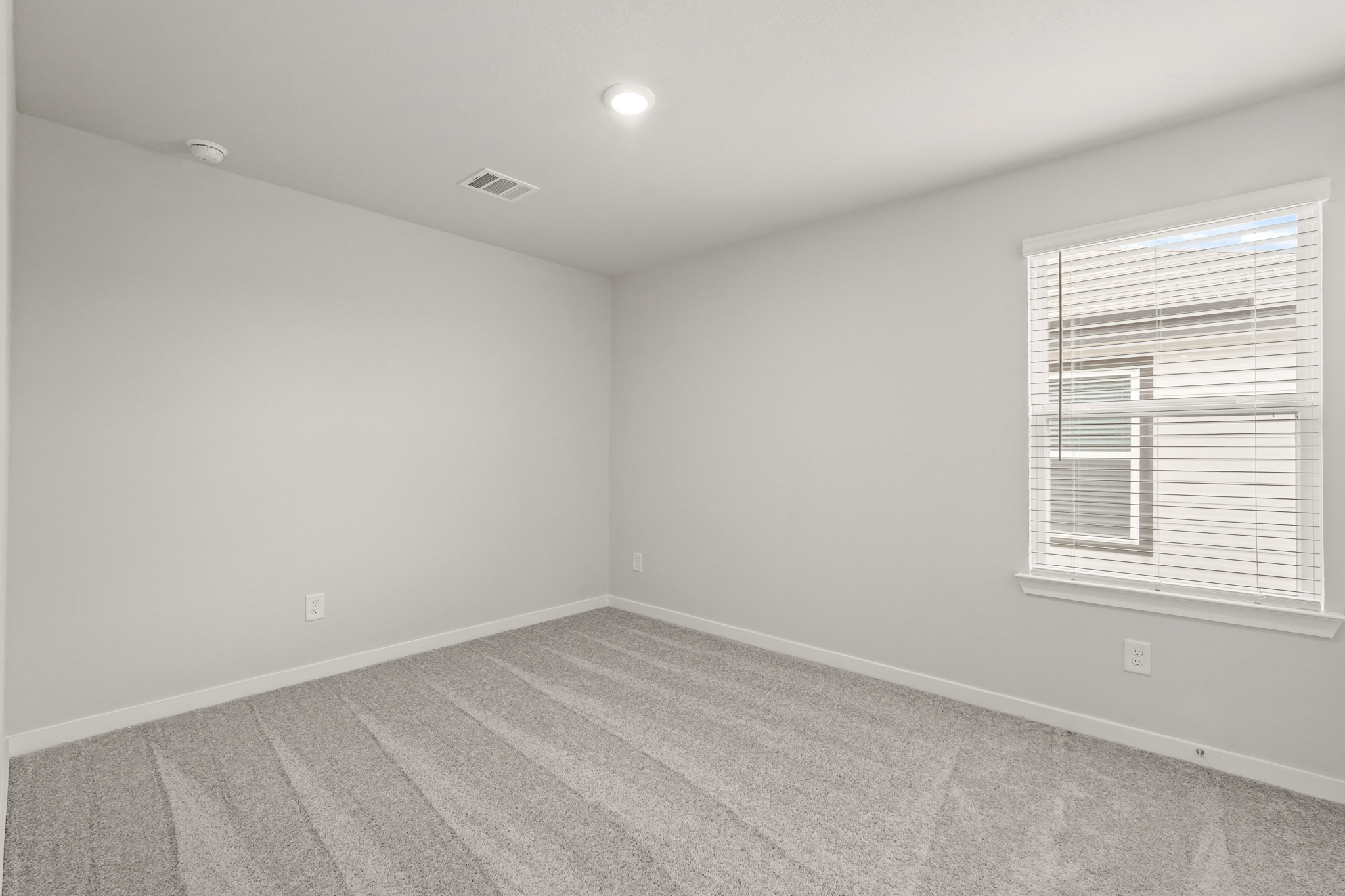 A room with a window and a rug.