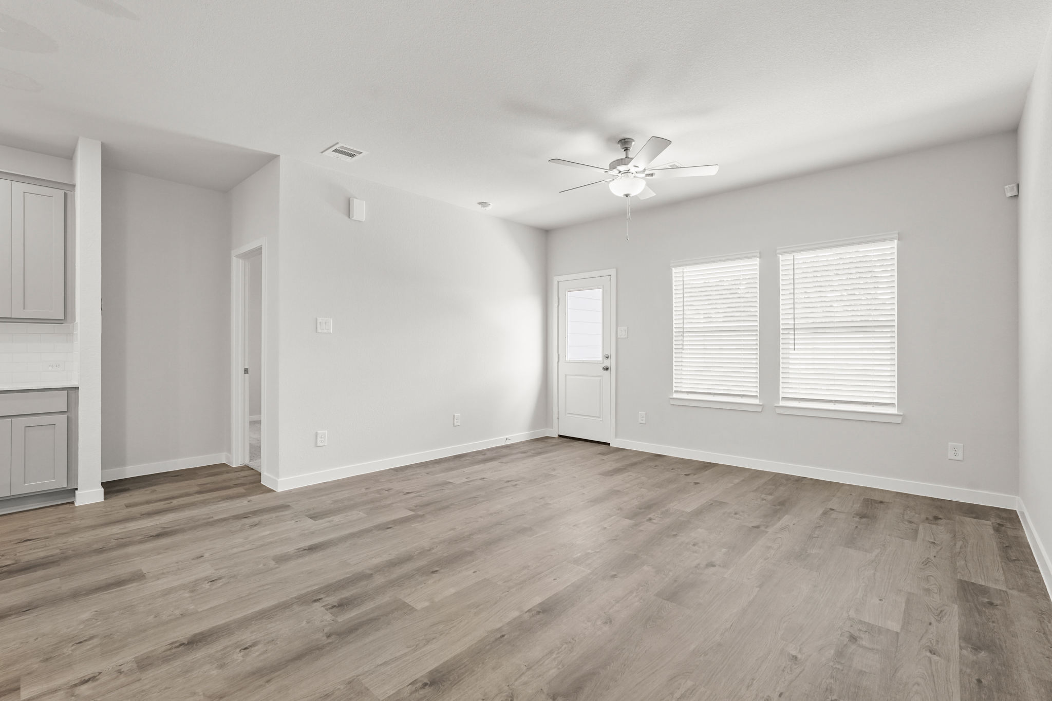 A room with a wood floor and a ceiling fan.