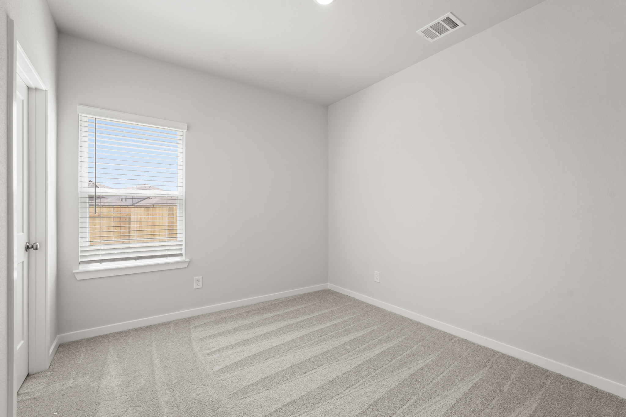 A room with a window and a rug.