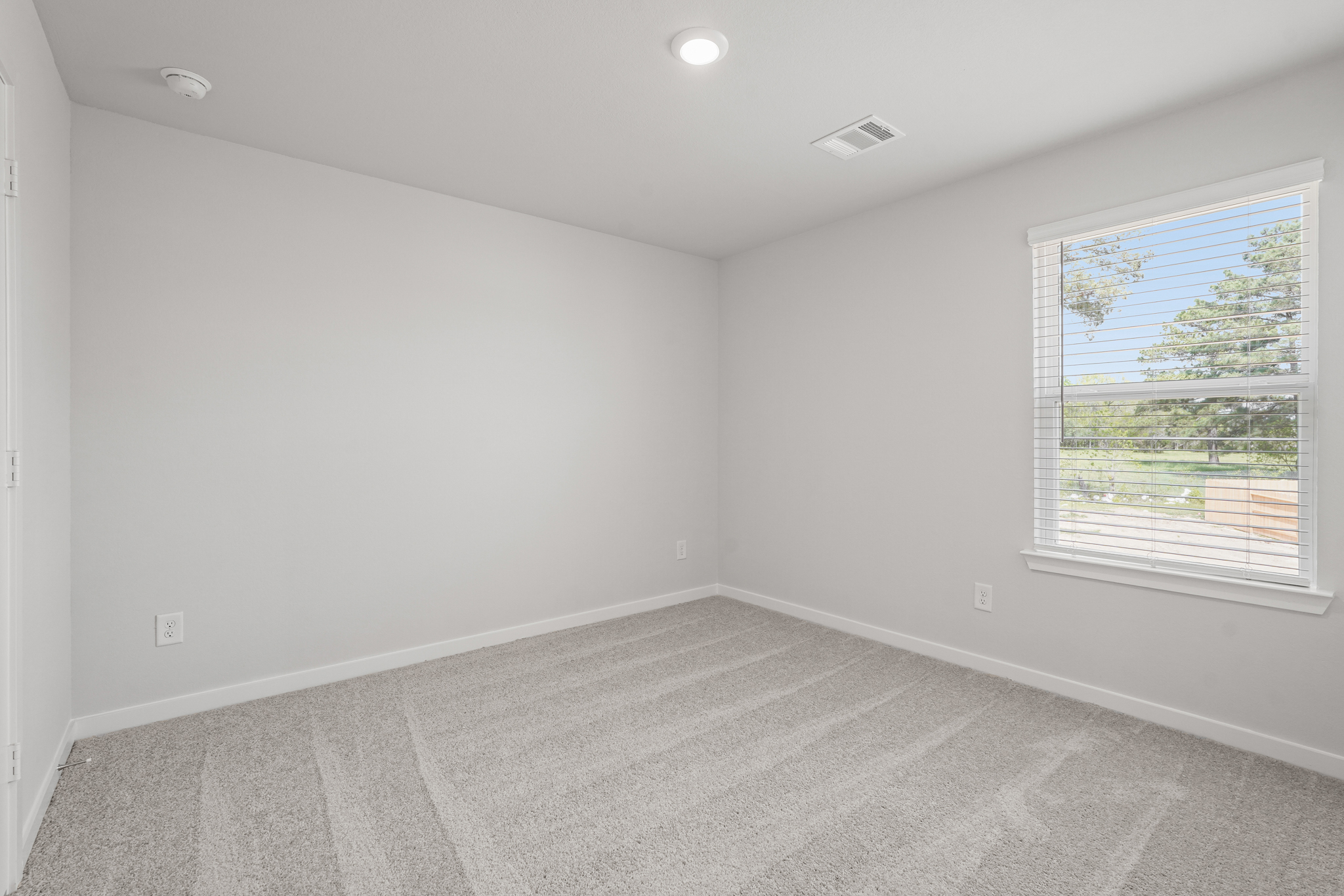 A room with a window and a carpet.