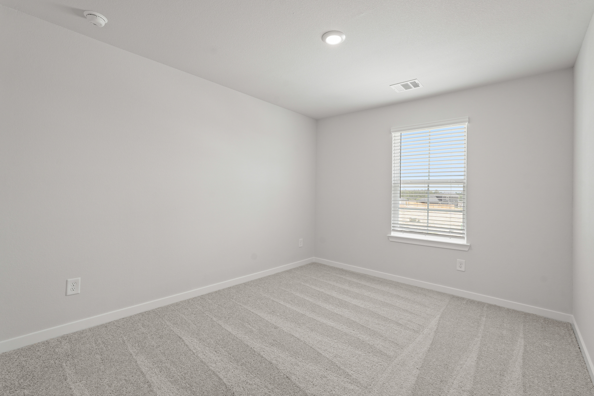 A room with a window and a rug.