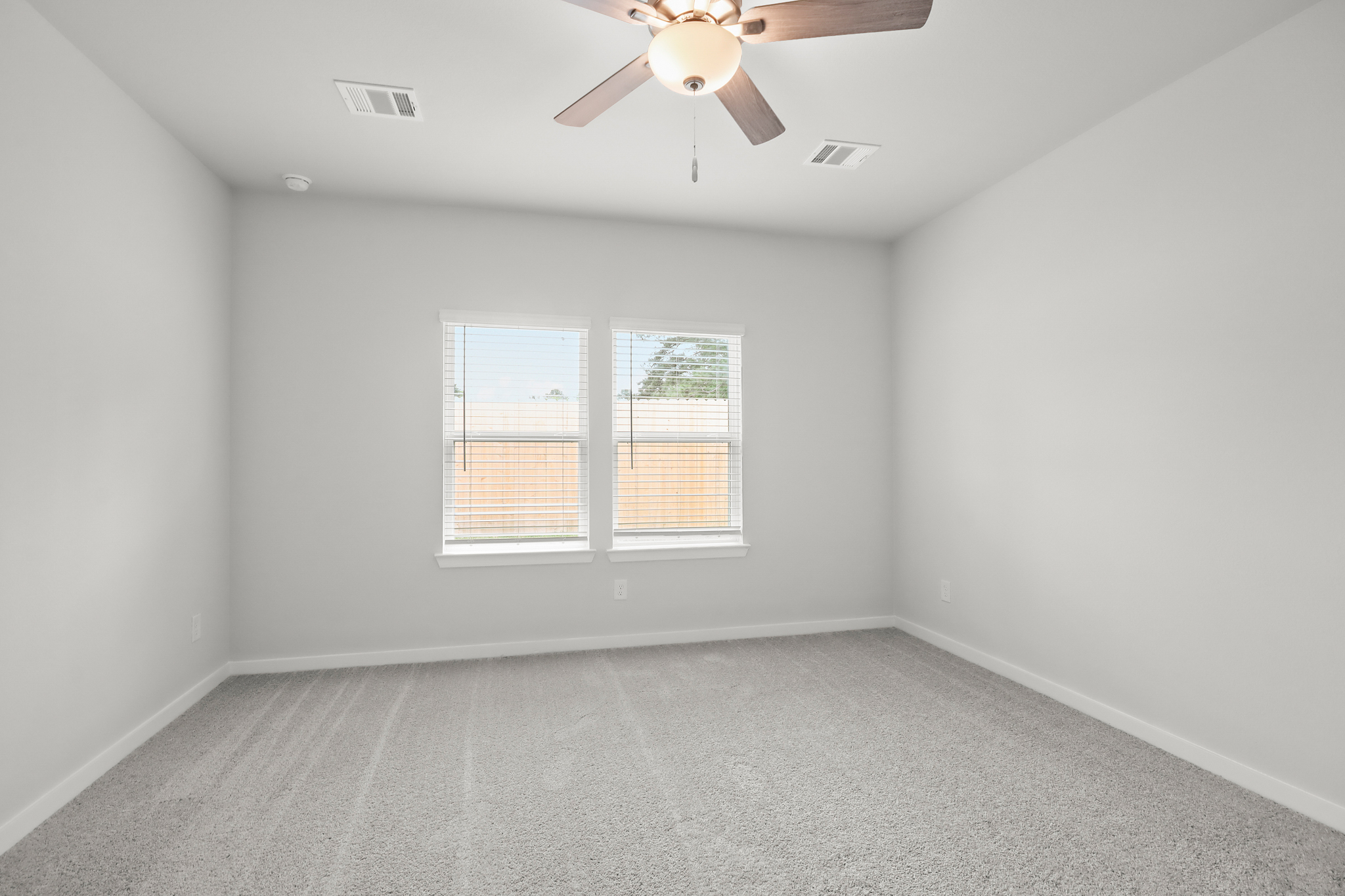 A room with a ceiling fan and a window.