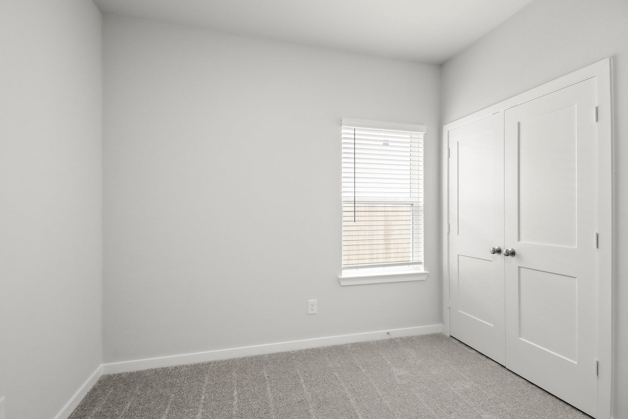 A room with white doors and a window.