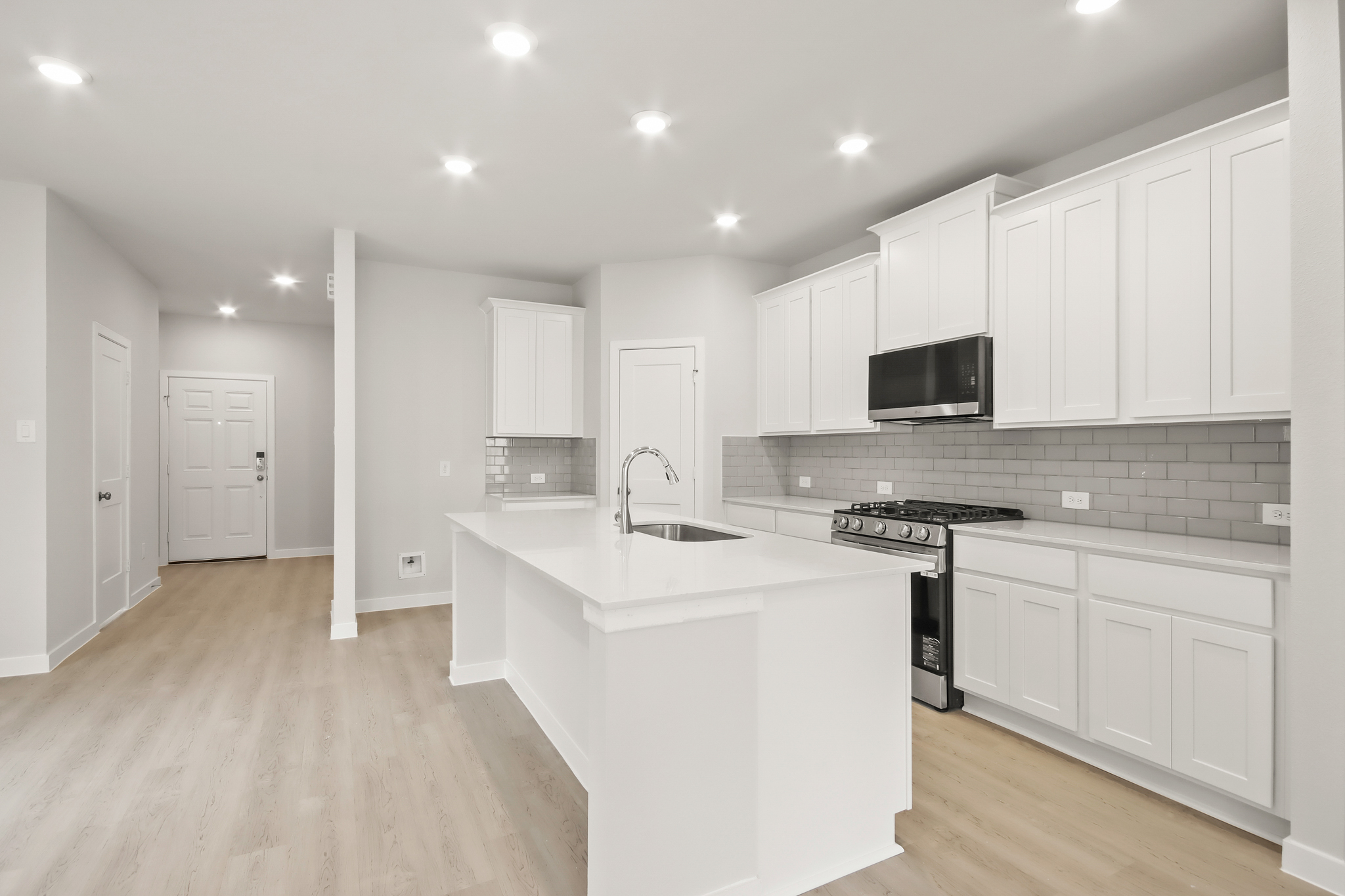 A kitchen with white cabinets.