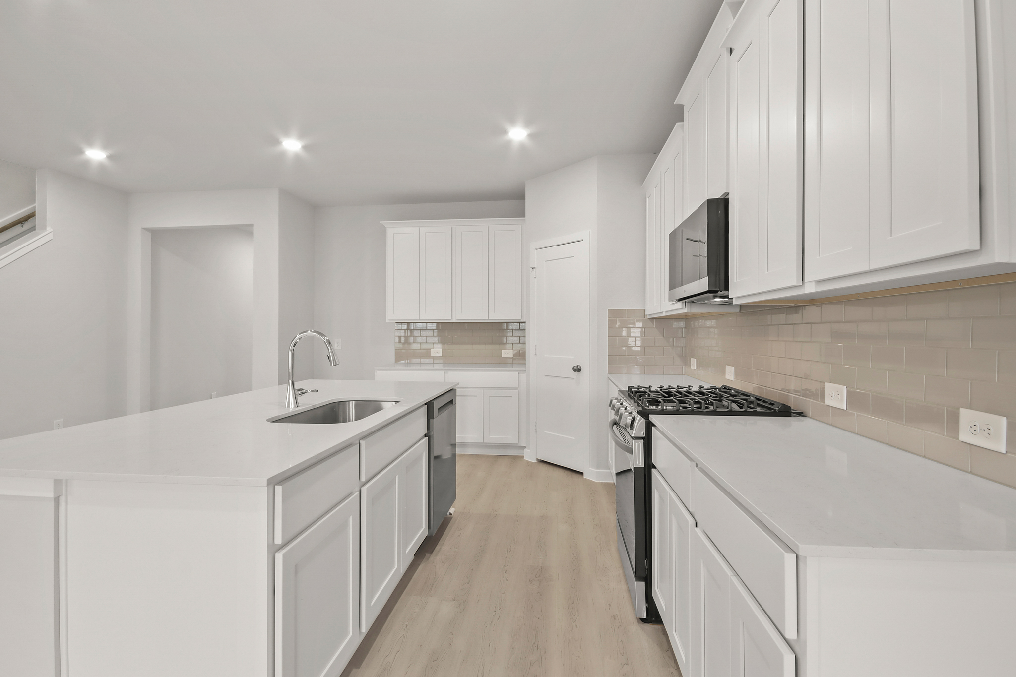 A kitchen with white cabinets.