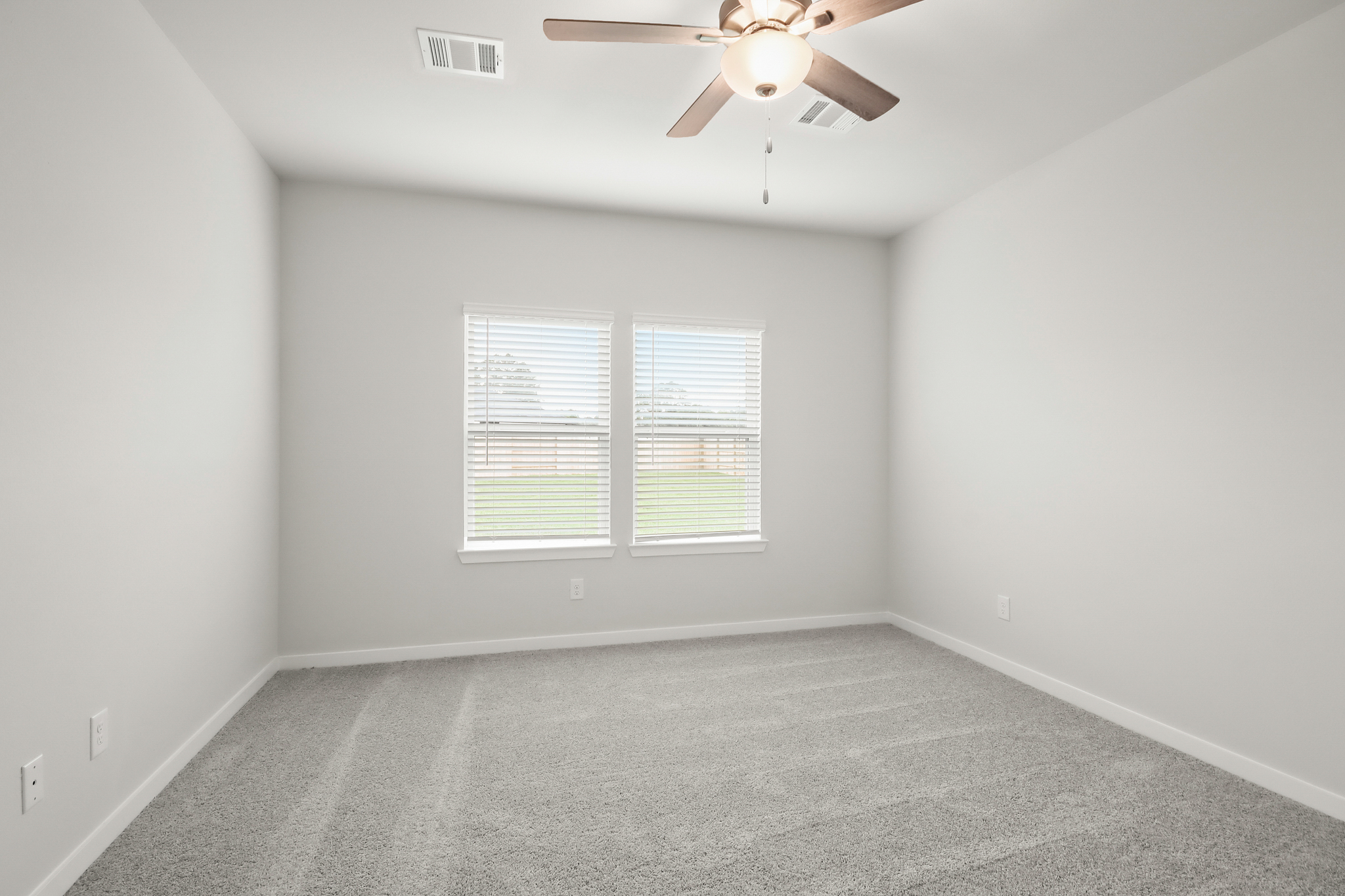 A room with a ceiling fan and a window.