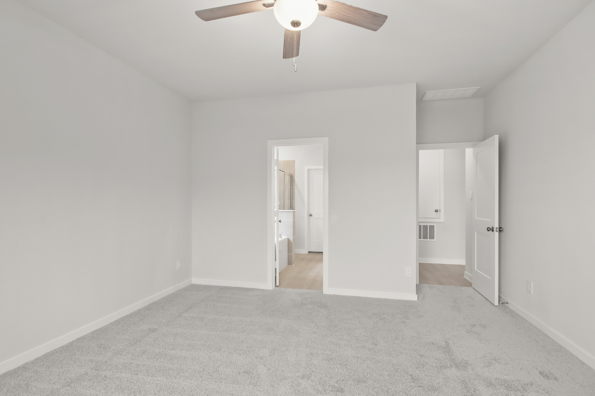 A room with white walls and a ceiling fan.