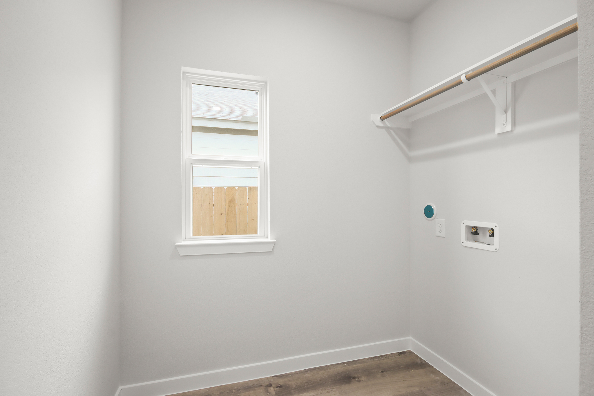 A white wall with a window and a white railing.