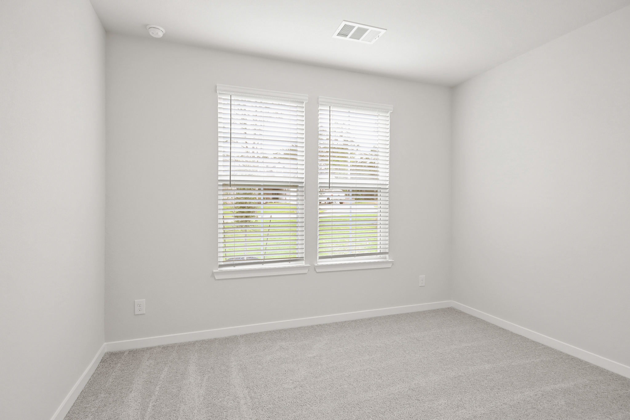 A room with a window and a carpet.