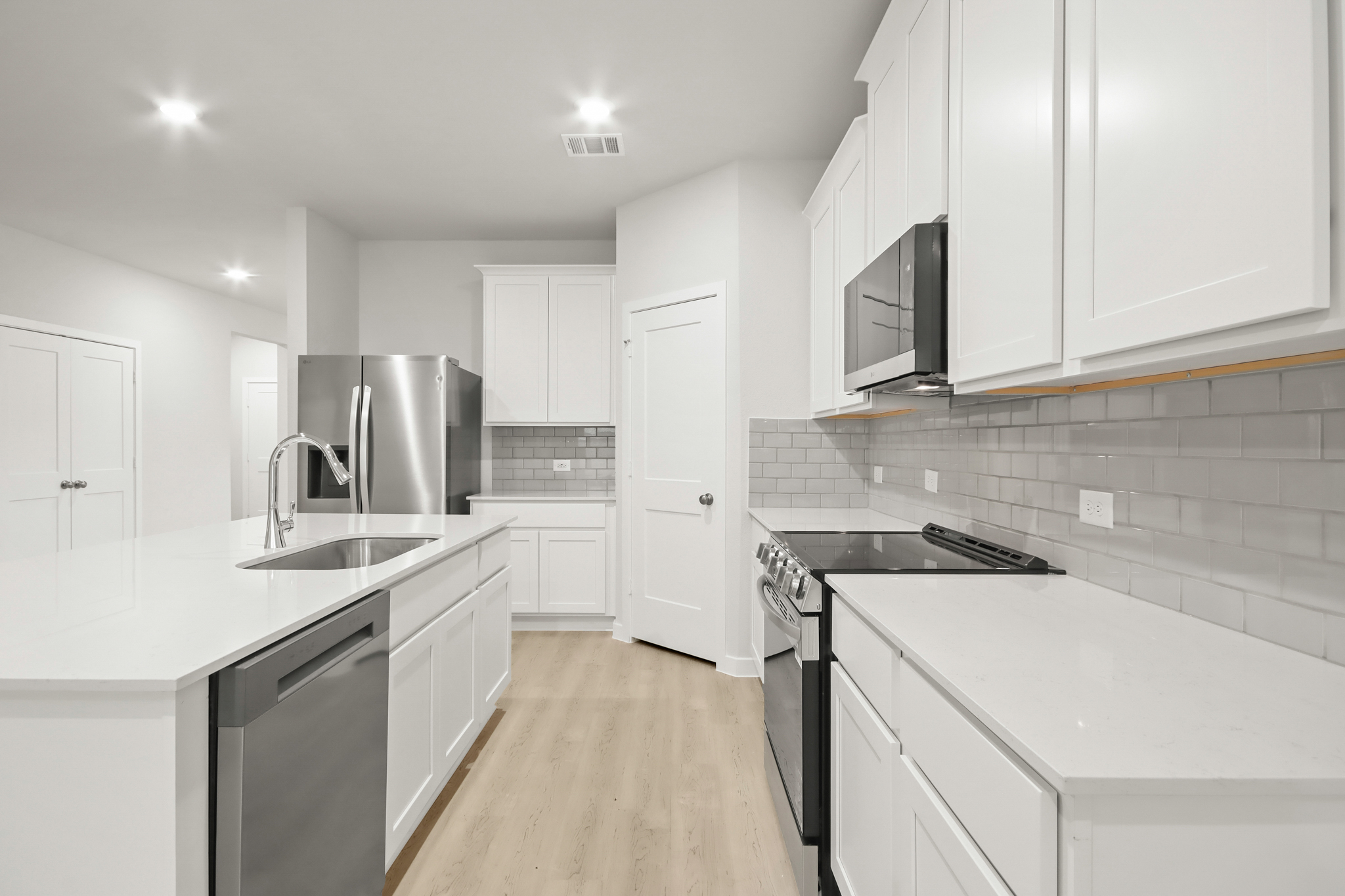 A kitchen with white cabinets.