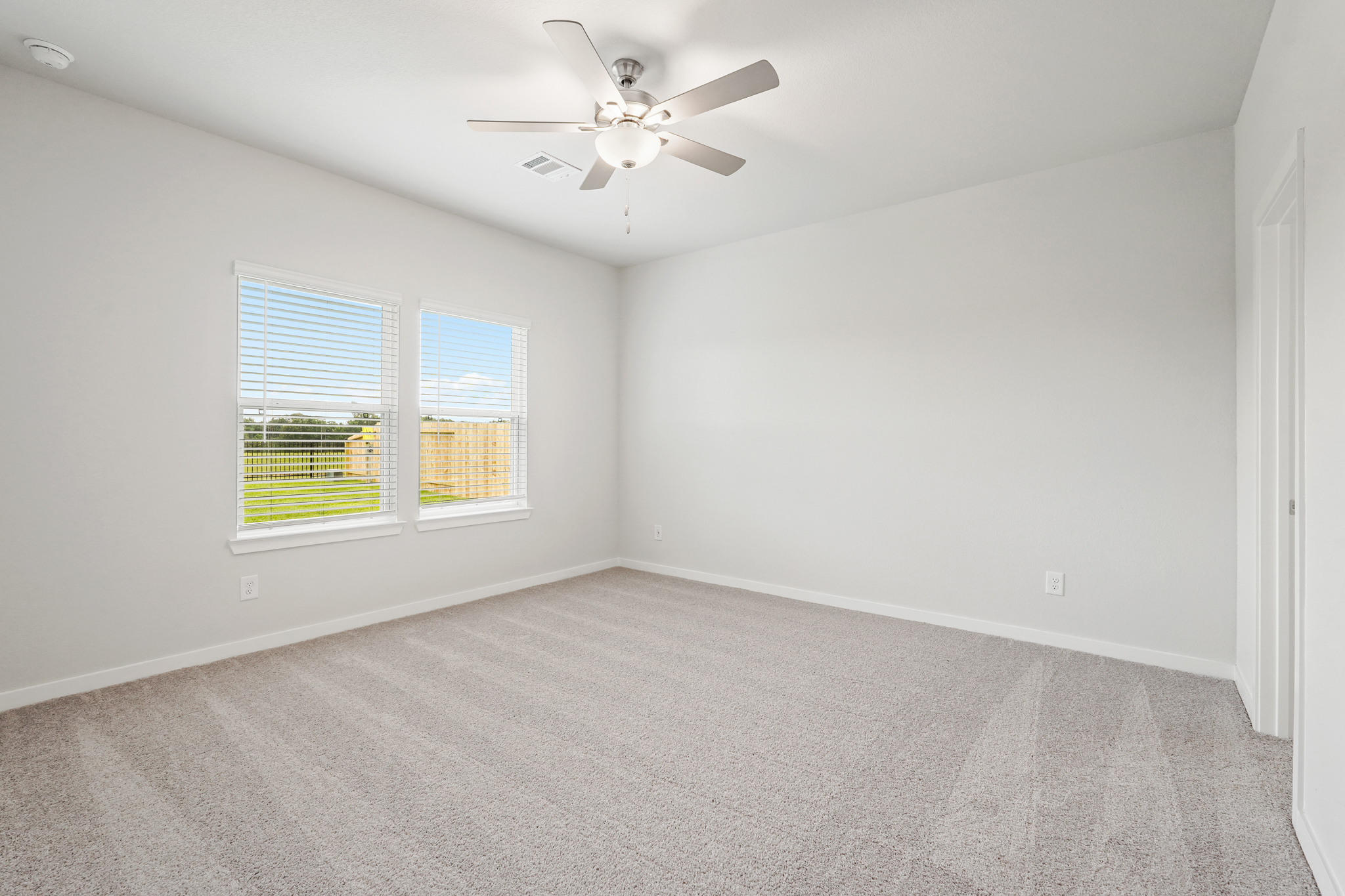 A room with a ceiling fan and a window.