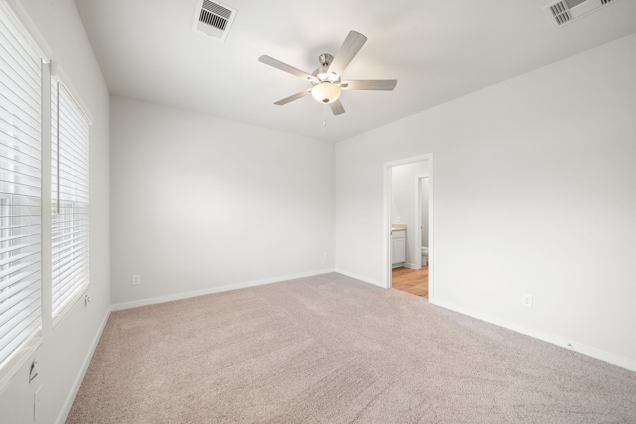 A room with a ceiling fan and a door.