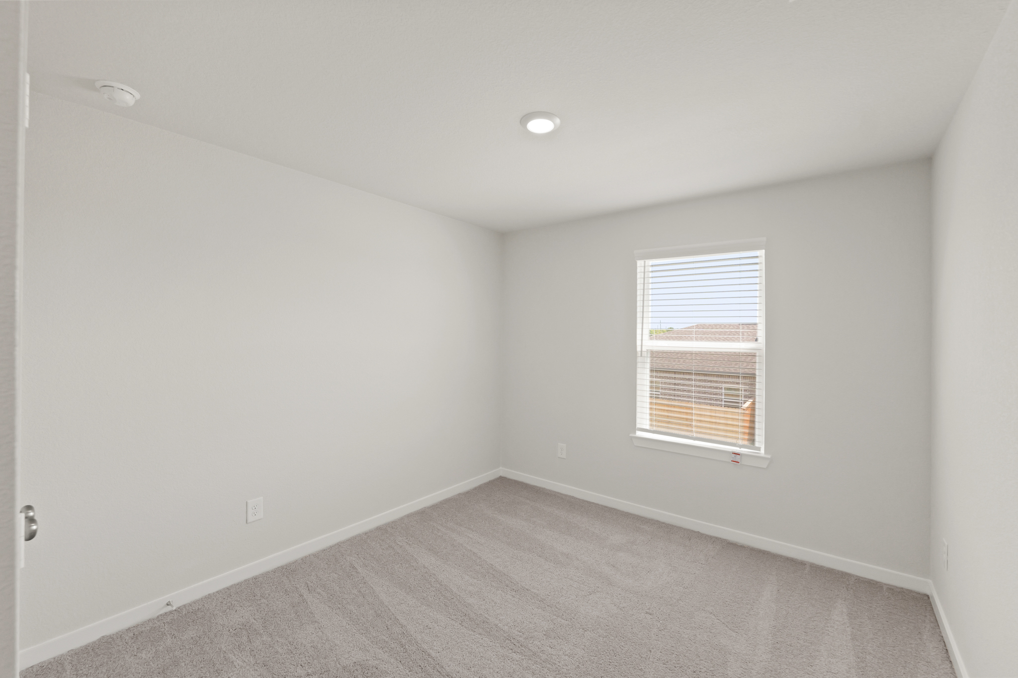 A room with a window and a carpet.