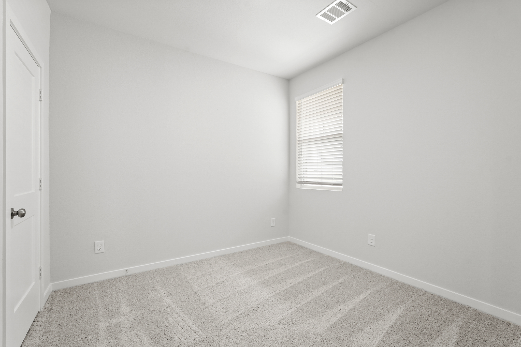 A room with a carpet and a window.