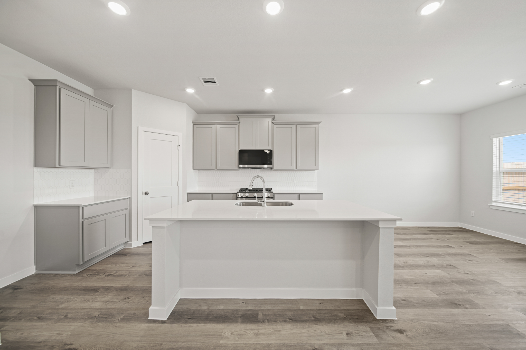 A large white kitchen with white cabinets.