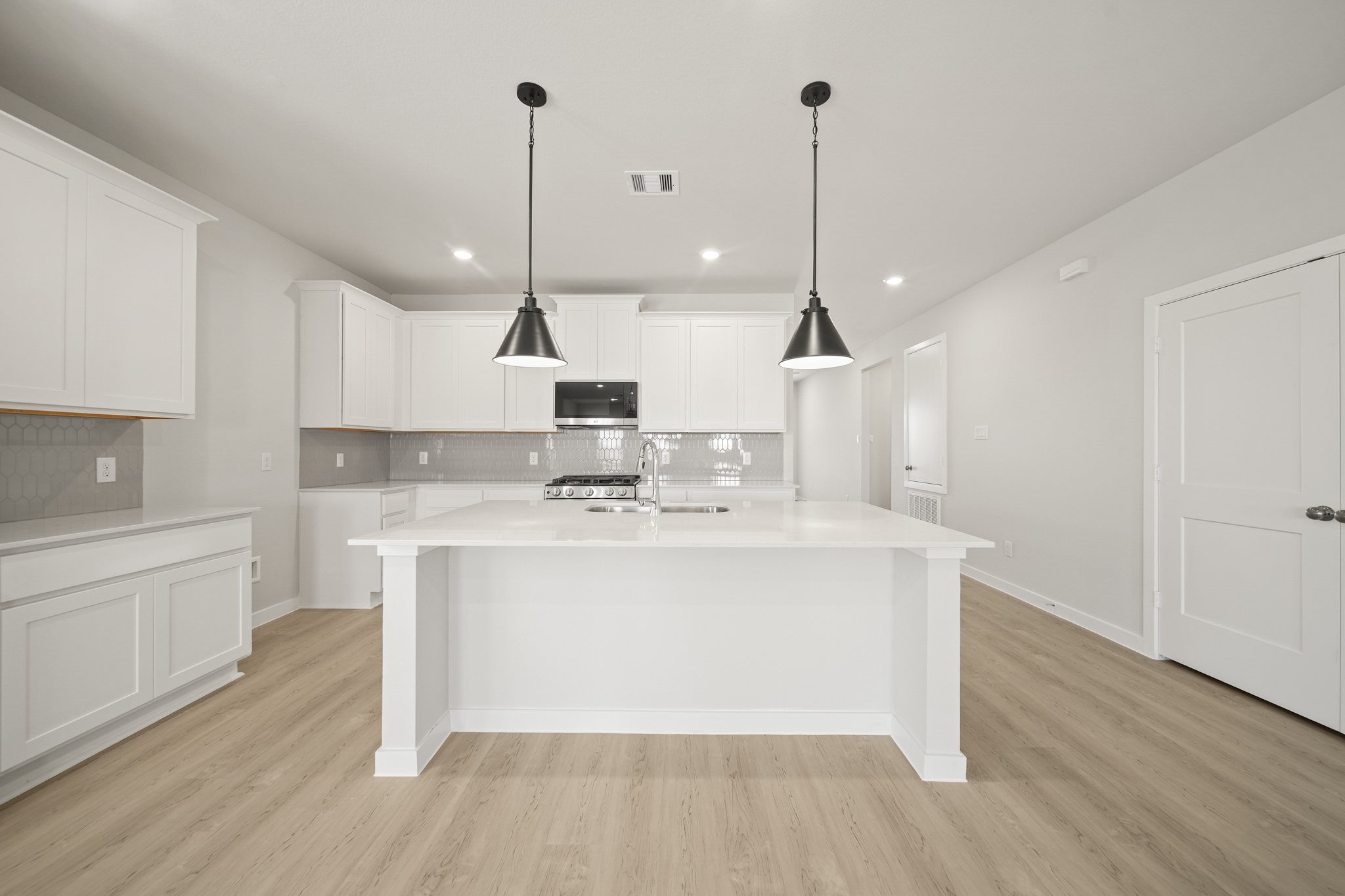 A kitchen with white cabinets.