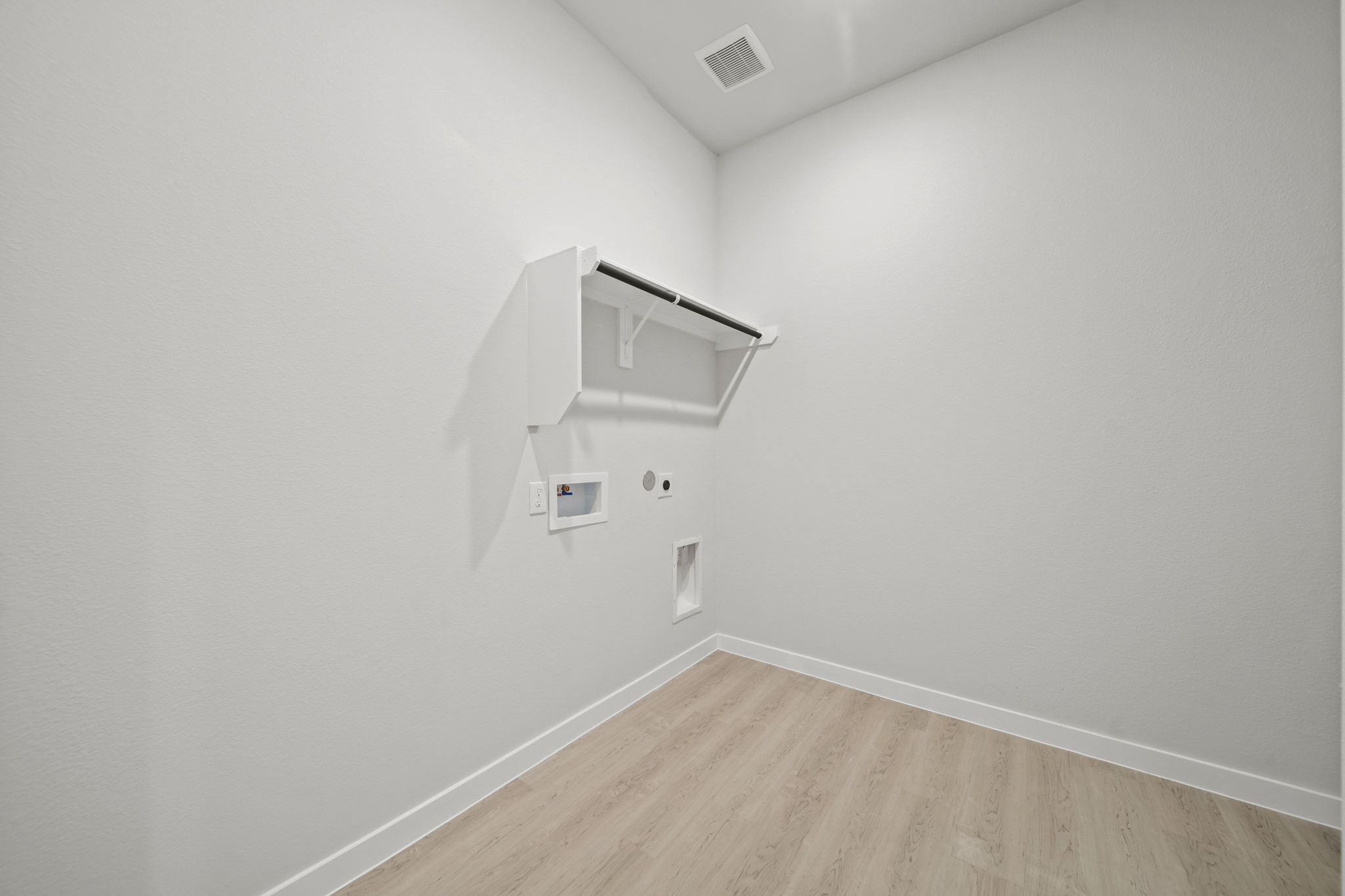 A white room with a wood floor.
