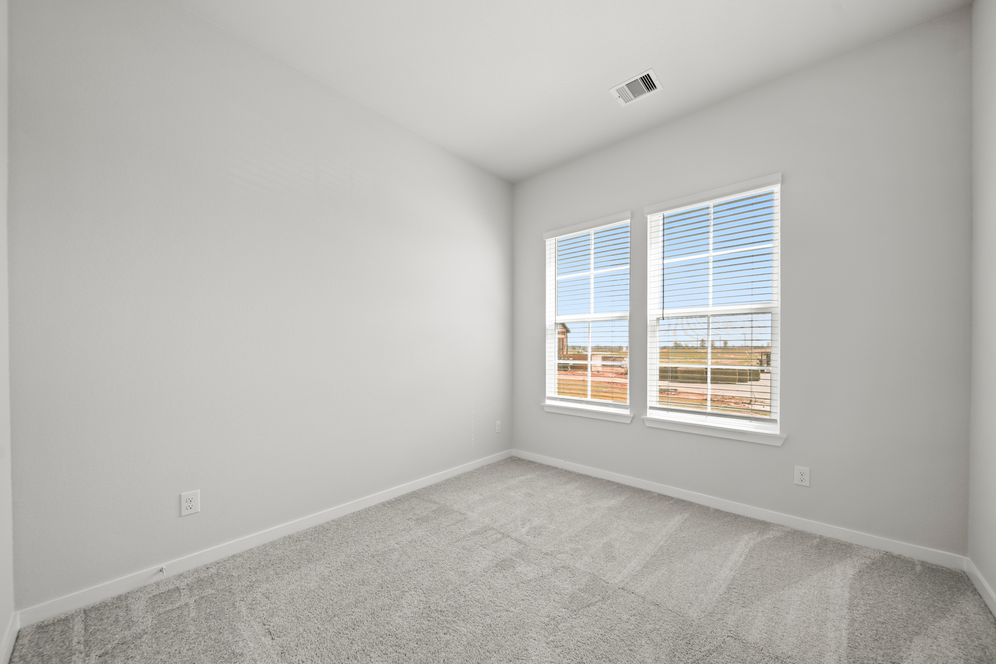 A room with a window and a carpet.