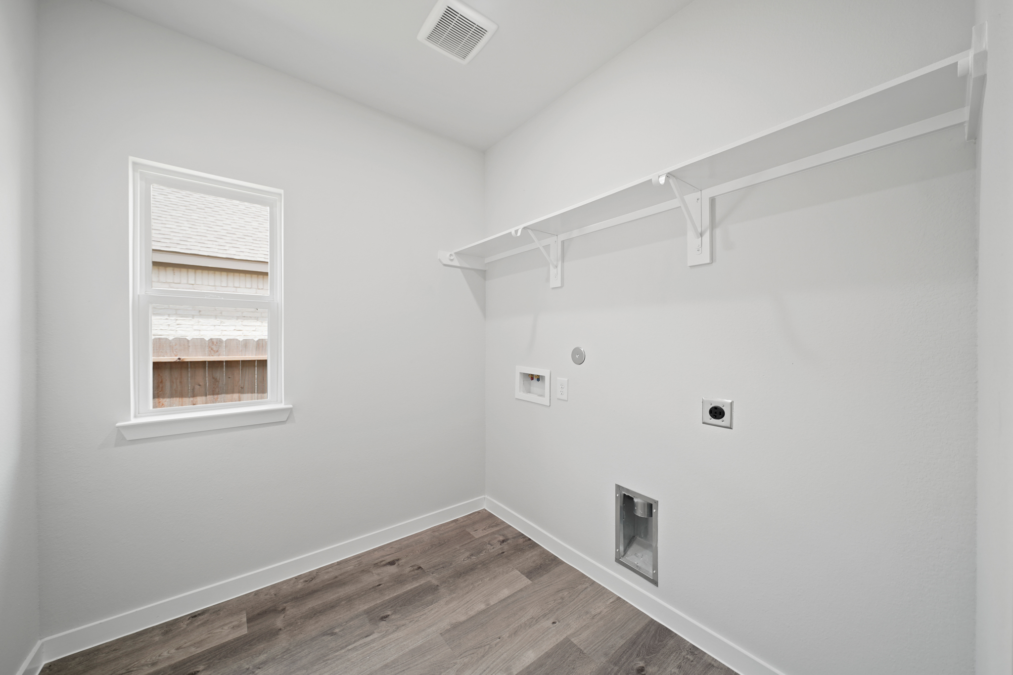 A room with a wood floor and a window.