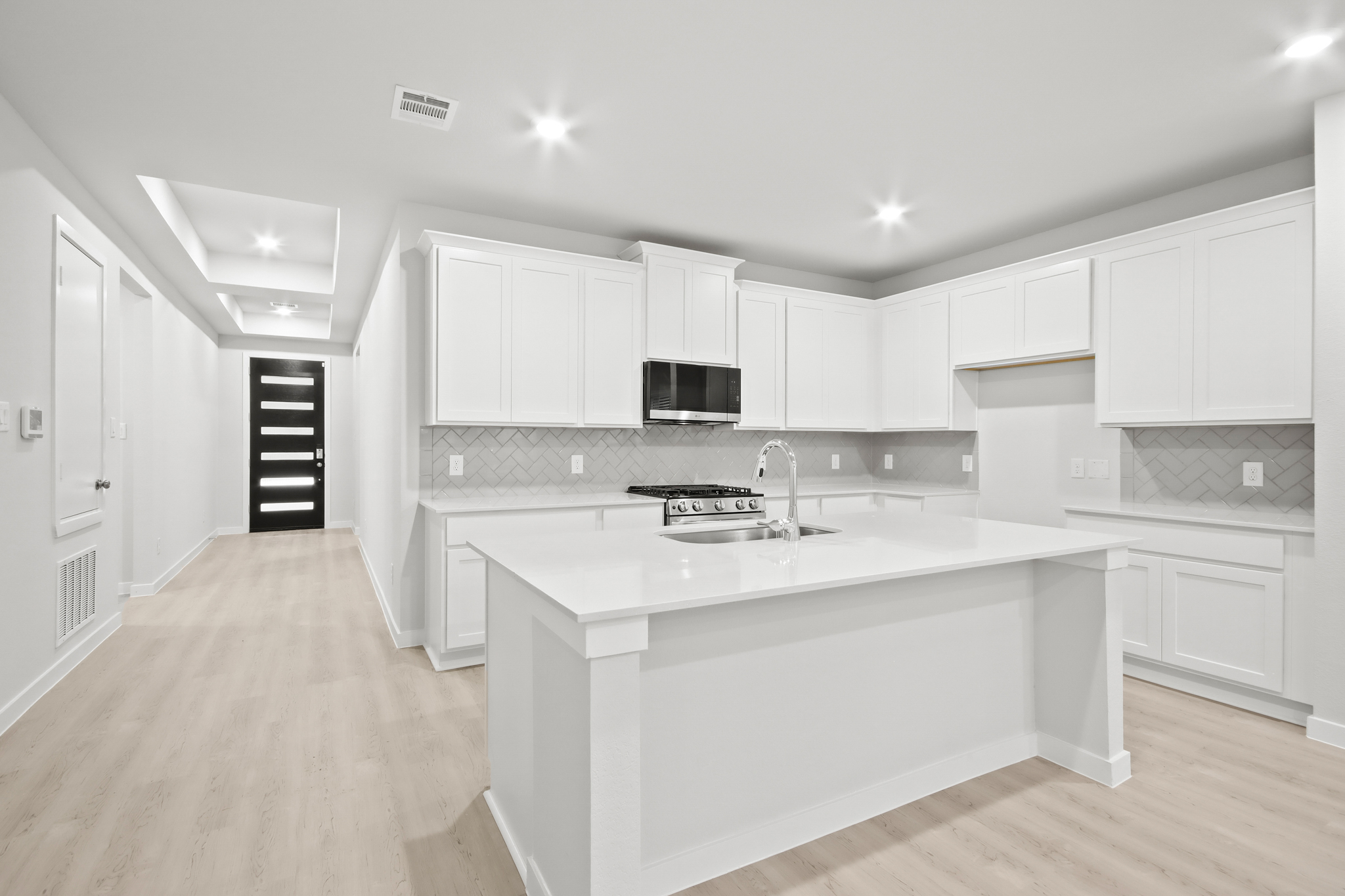 A kitchen with white cabinets.