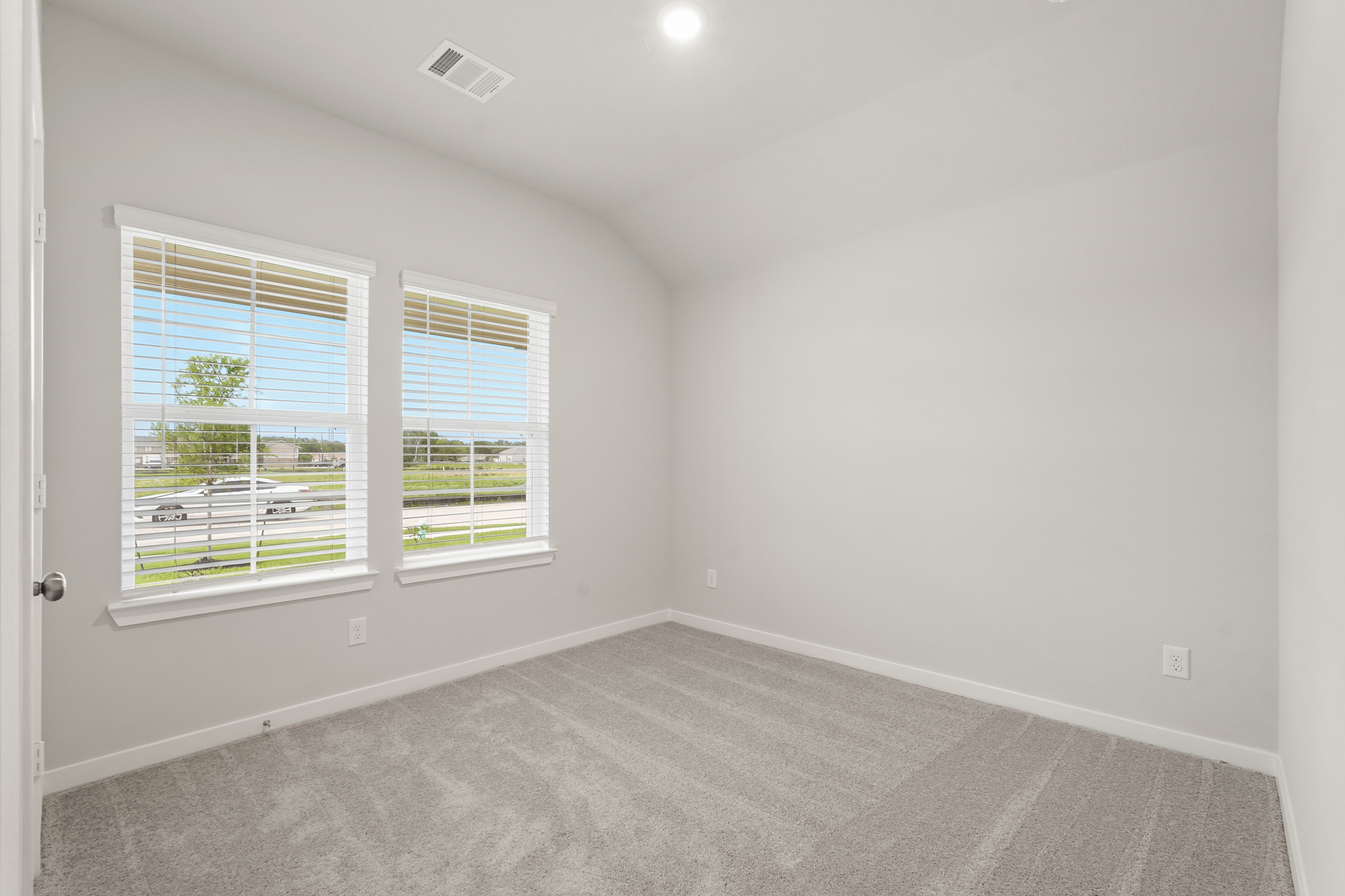 A room with a window and a carpet.