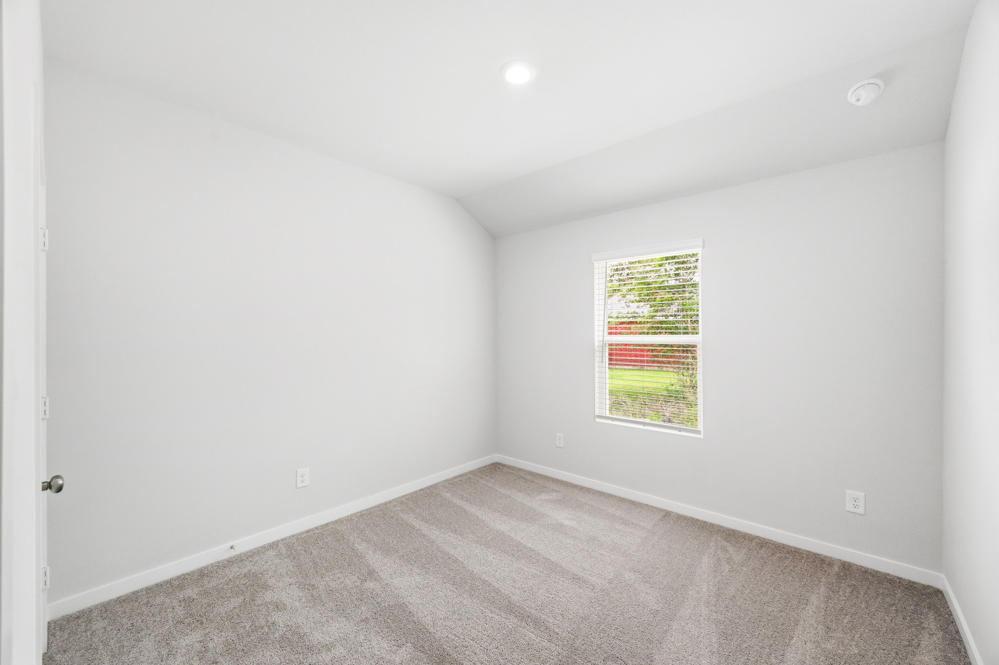 A room with a window and carpet.