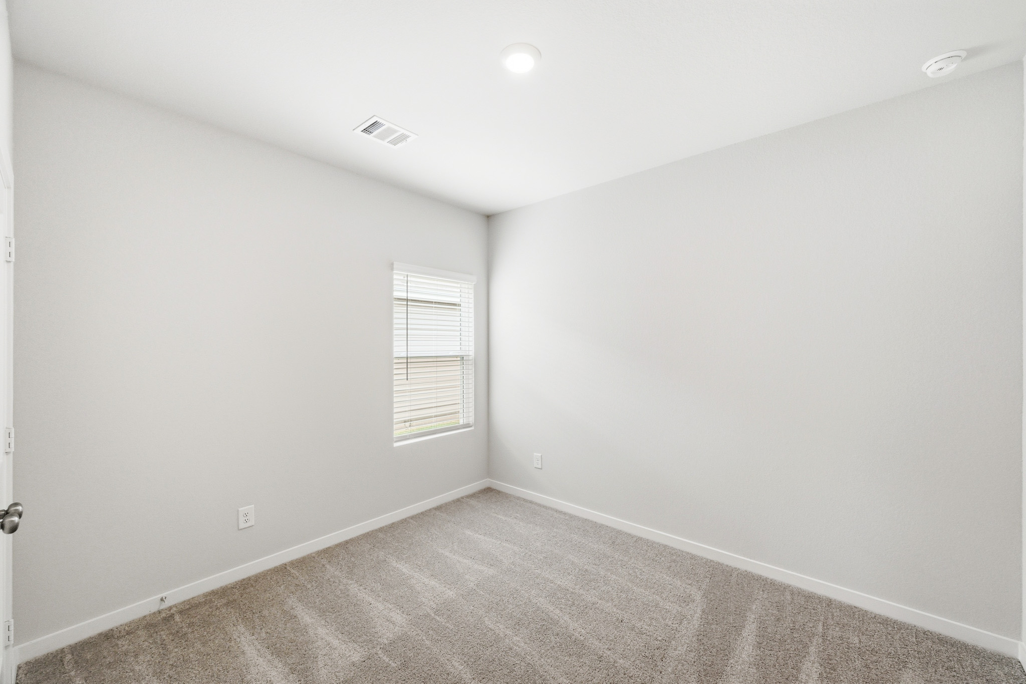 A room with a carpet and a window.