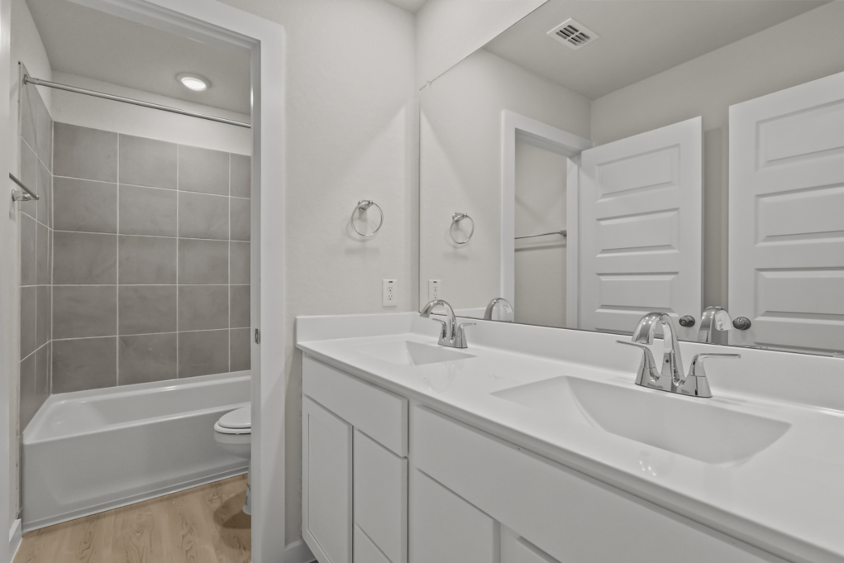 A bathroom with a tub sink and toilet.