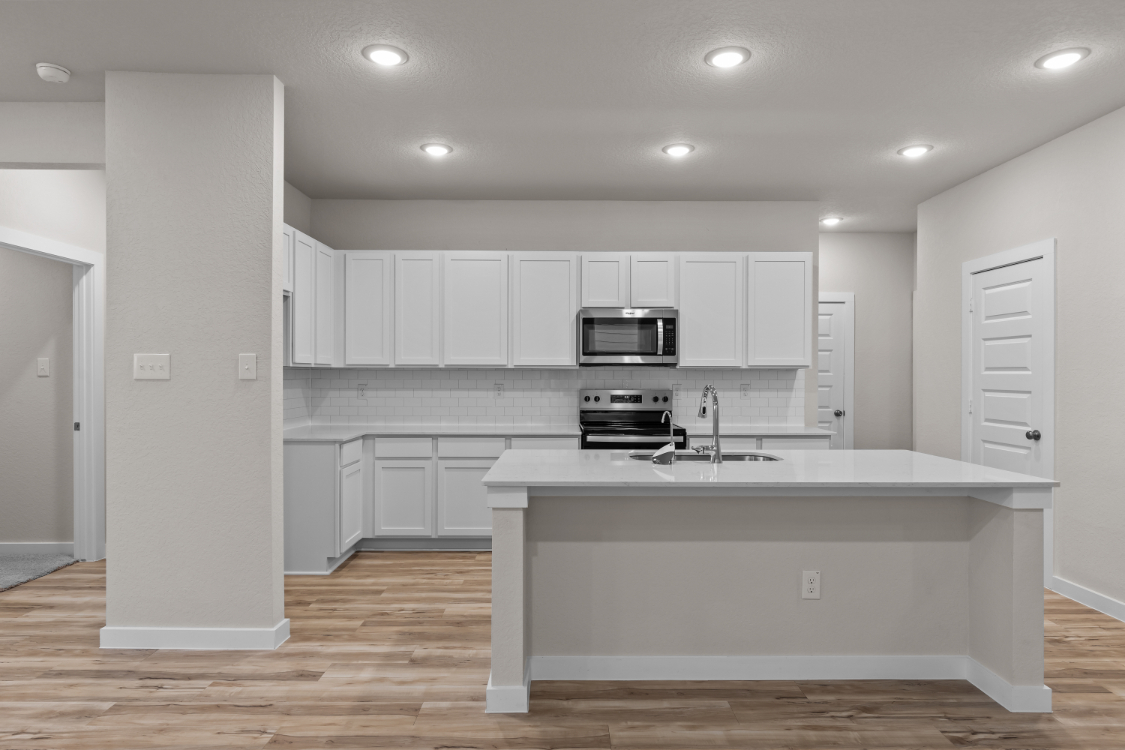 A kitchen with white cabinets.