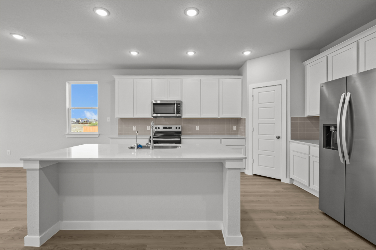 A kitchen with white cabinets.