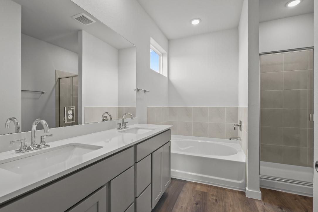 A bathroom with a tub sink and a shower.