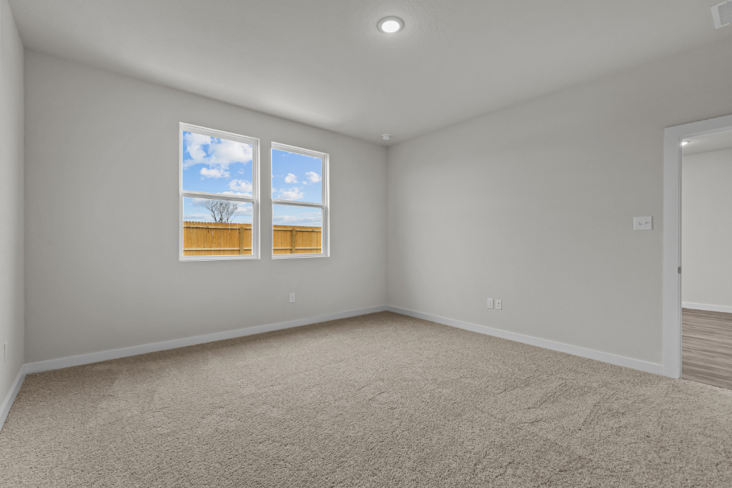 A room with a carpet and a rug and a window.