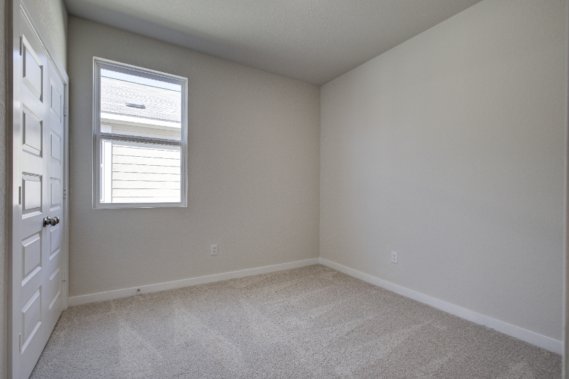 A room with white walls and a window.