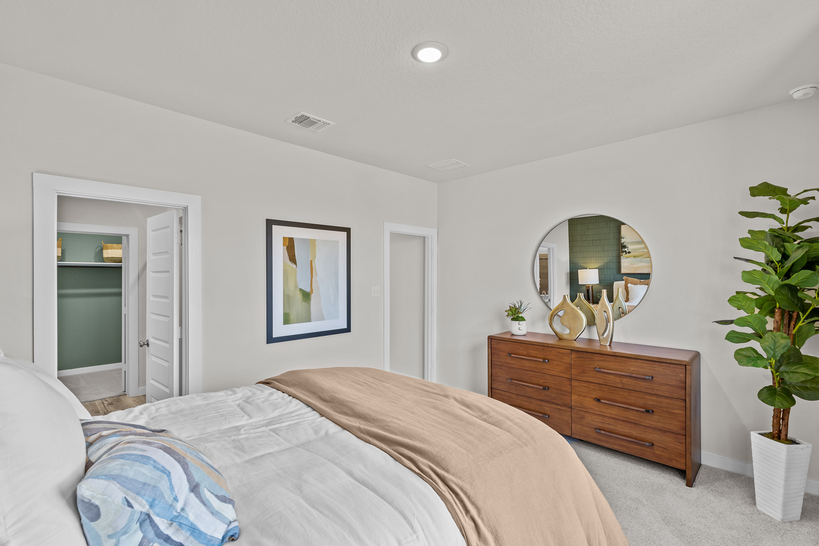 A bedroom with a bed and a mirror.