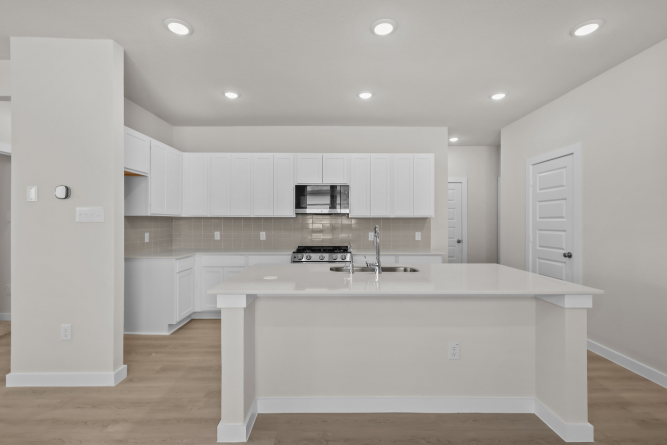 A kitchen with white cabinets.
