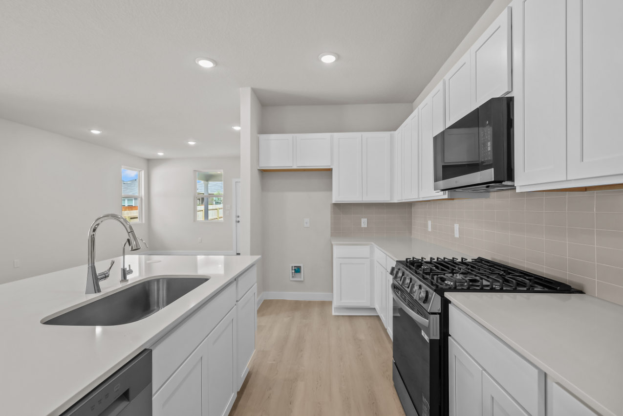 A kitchen with white cabinets.