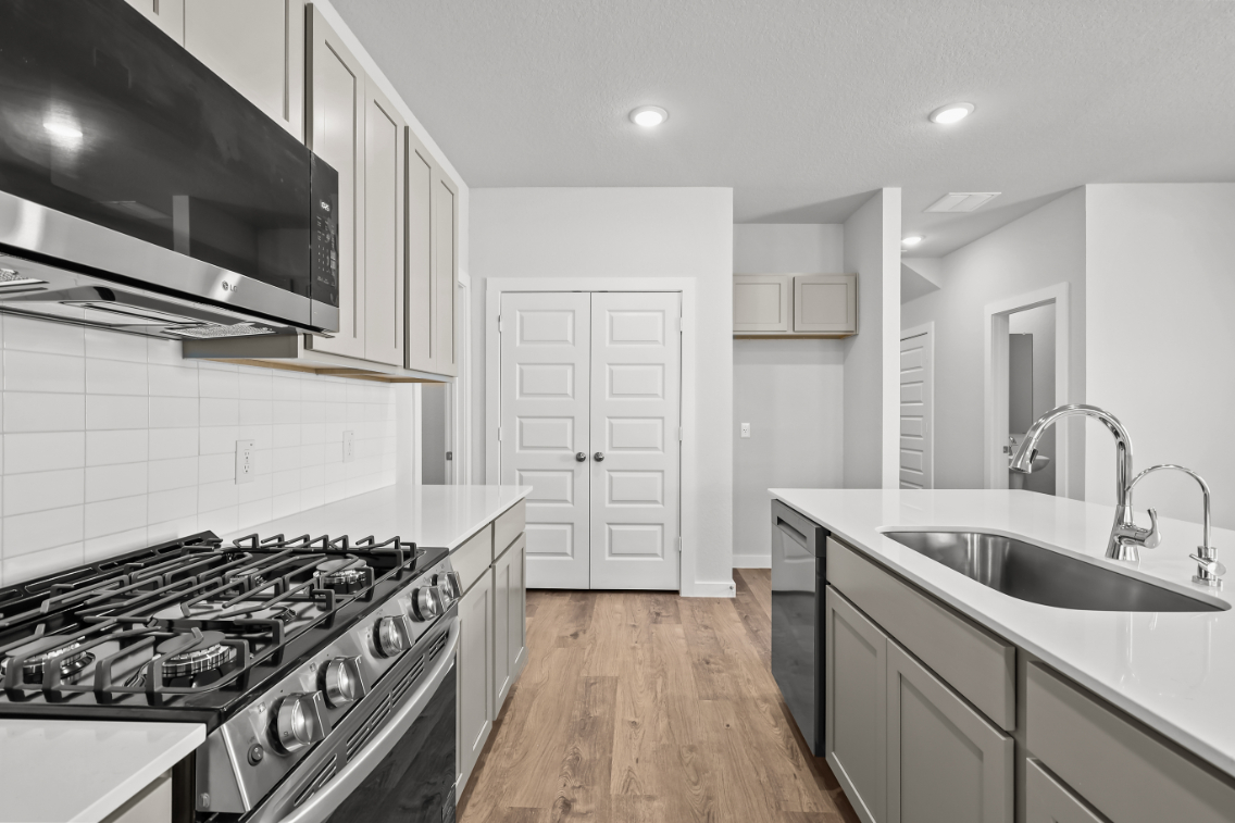 A kitchen with white cabinets.
