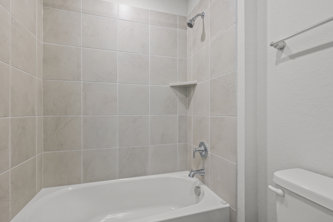 A bathroom with a bathtub and toilet.